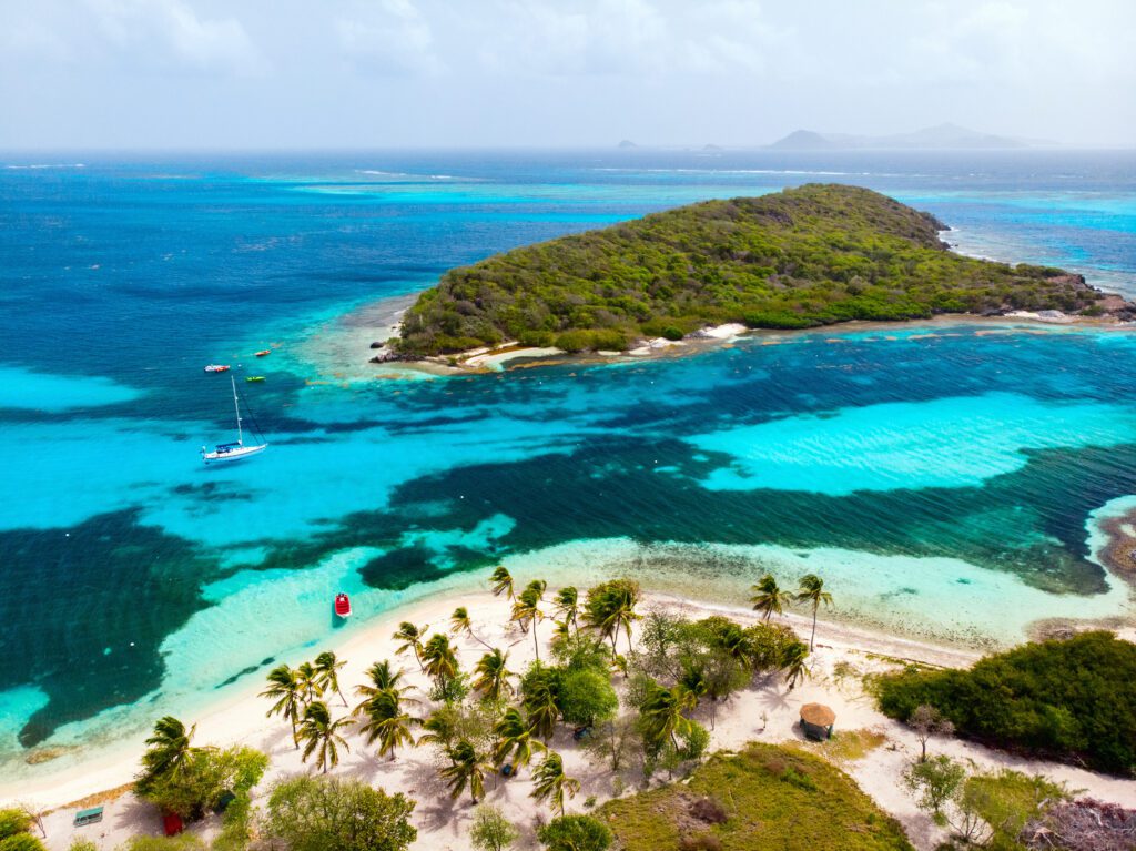 Exclusive Yachts - Aerial drone view of tropical islands and turquoise Caribbean sea of Tobago cays in St Vincent and Grenadines