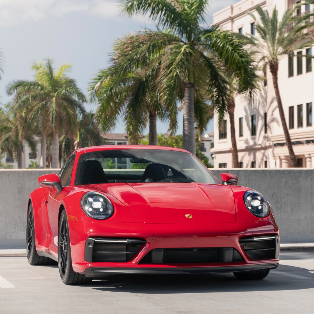 Porsche Naples - a Red Porsche with palm tree behnd it